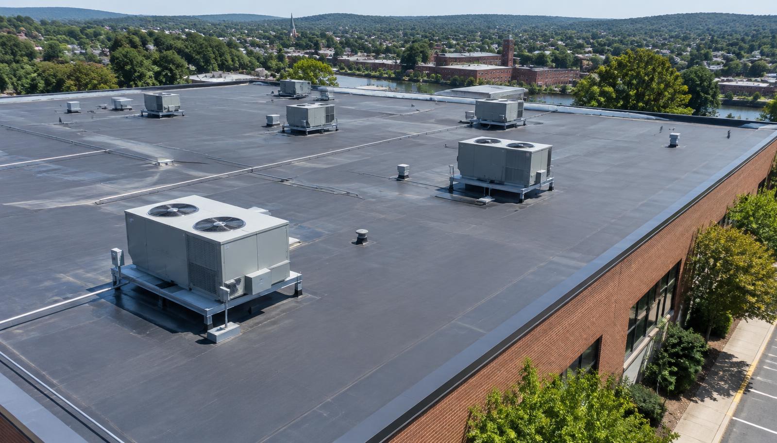 Low-slope commercial roof with rooftop HVAC units in Fitchburg, Massachusetts in late summer