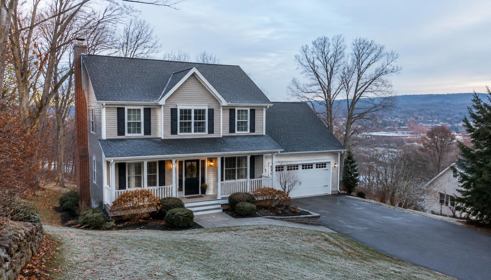 New England home in Fitchburg, Massachusetts during late fall just before winter, with a clean asphalt-shingle roof, bare trees, and light frost